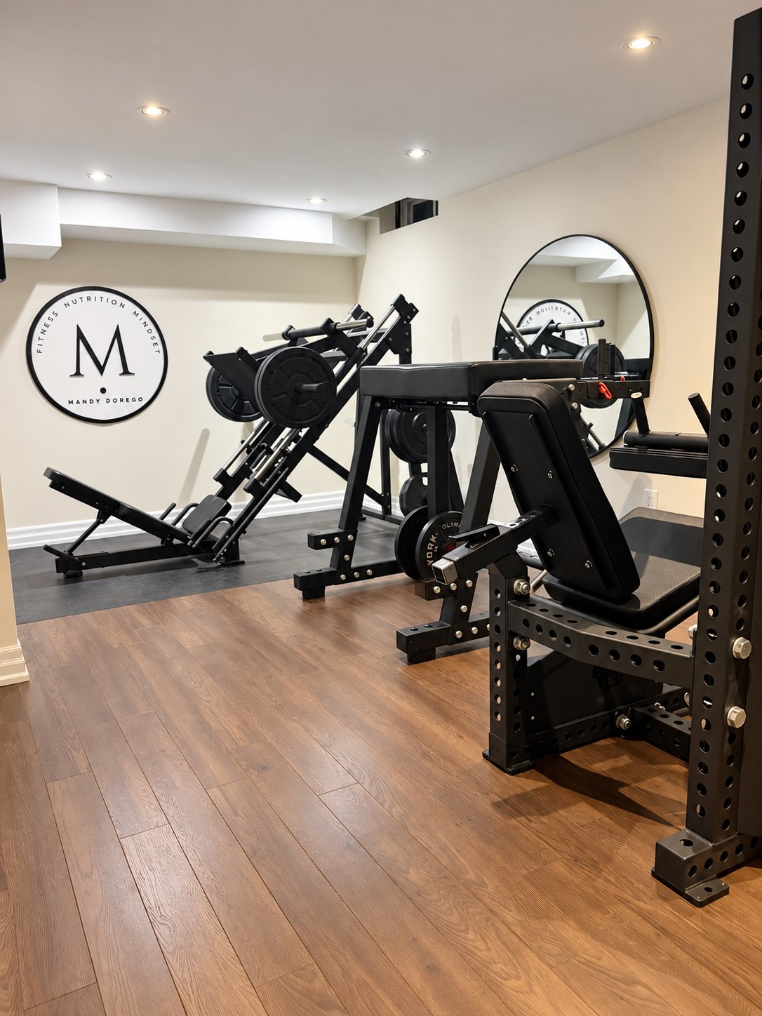 Inside Mandy's private training studio in Markham, with loaded leg machines and the Fitness Evolution wall sign